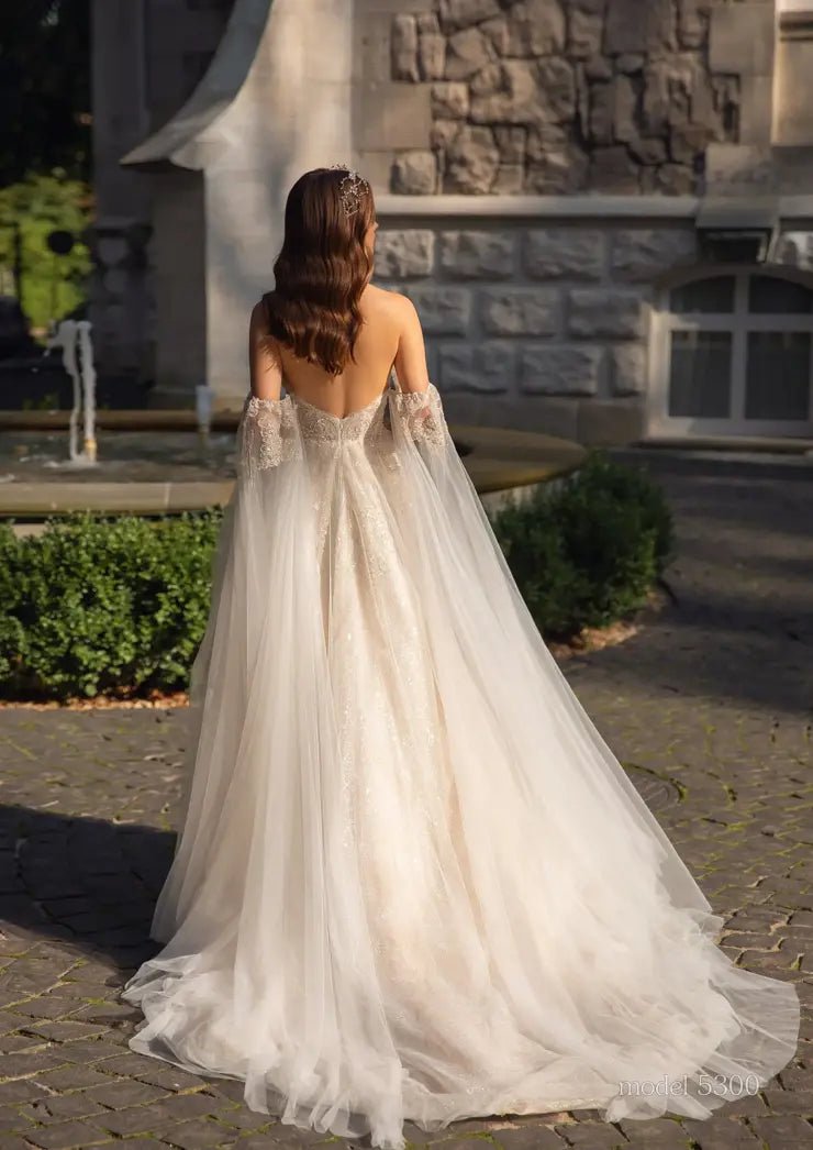 GENIVEVE Corset style beaded bodice with beaded tulle skirt. Shoulder drapes/ cape - Reflections Bridal Studio