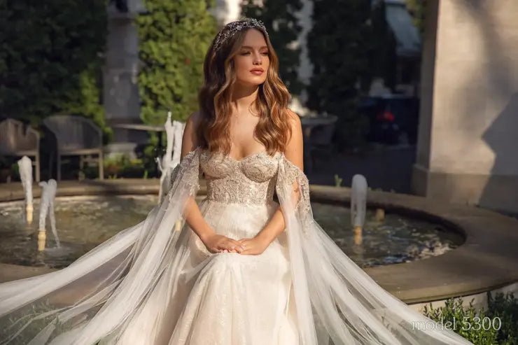 GENIVEVE Corset style beaded bodice with beaded tulle skirt. Shoulder drapes/ cape - Reflections Bridal Studio