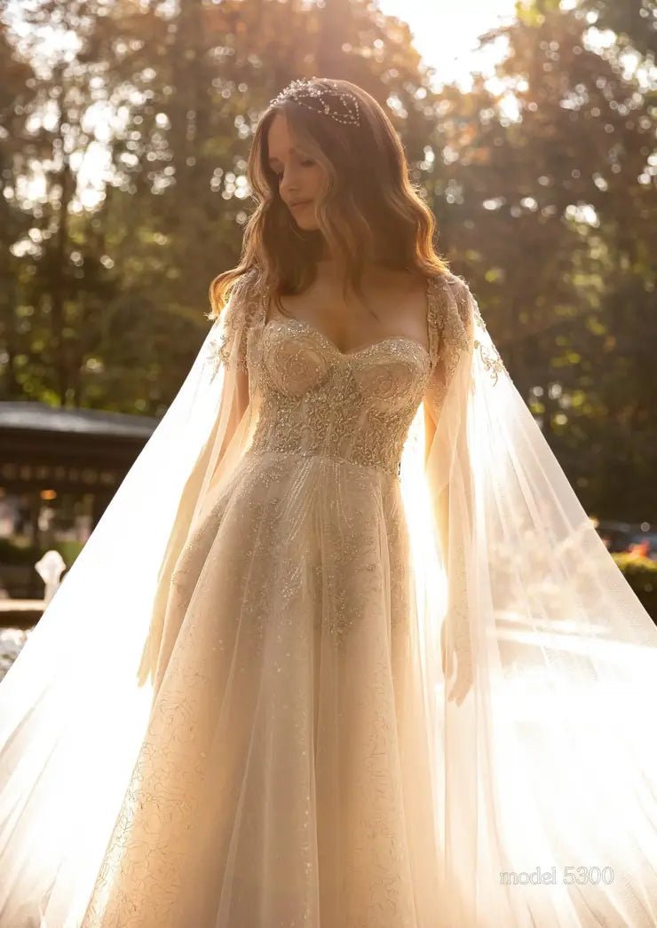 GENIVEVE Corset style beaded bodice with beaded tulle skirt. Shoulder drapes/ cape - Reflections Bridal Studio