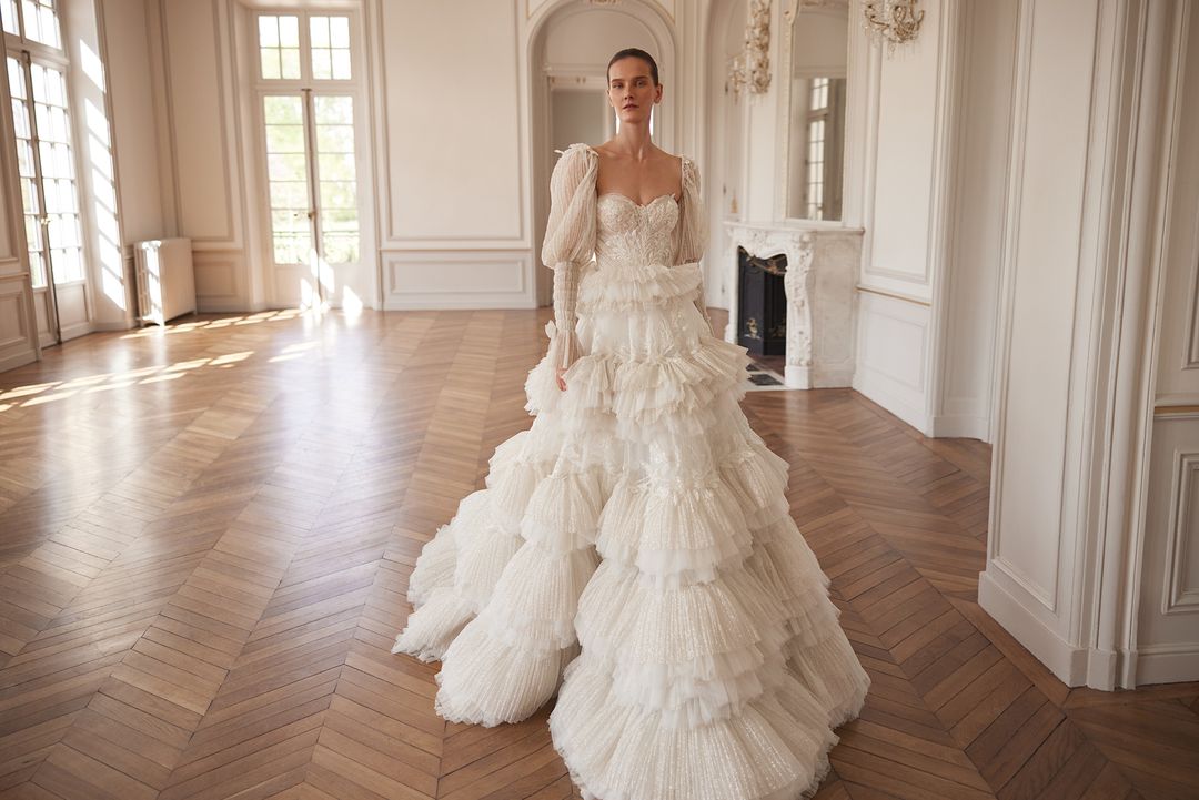 BASSEMA Indulgent layers of ruffles with glitter and lace. Detachable sleeves - Reflections Bridal Studio